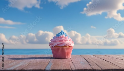 A pink frosted cupcake on a wooden surface with a blue sky and clouds in the background photo