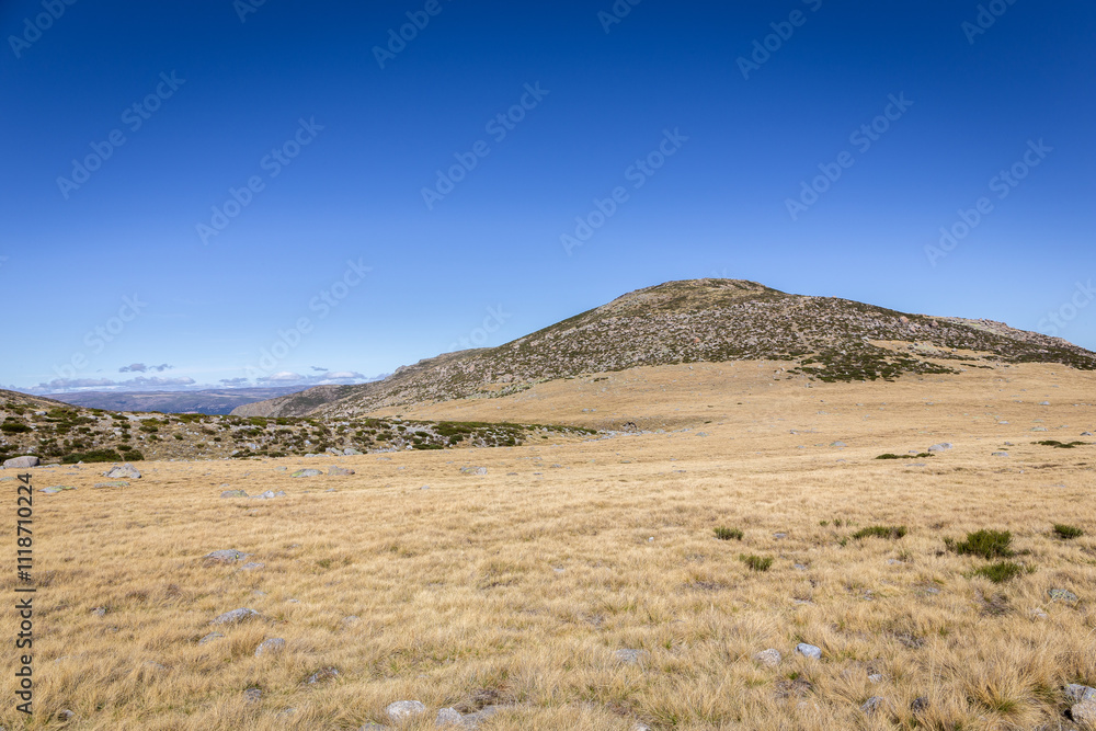 Naklejka premium Sierra de Gredos mountain landscape in autumn, dry, barren vegetation and rocky hills, seen from the trail to the Laguna Grande de Gredos, Spain.