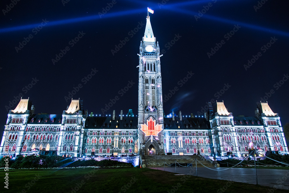 Fototapeta premium A large building with a clock tower and a large red maple leaf on the roof