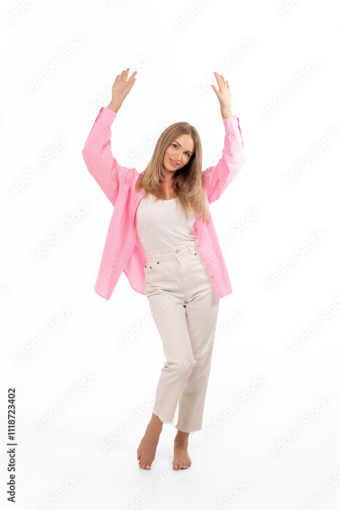 Woman poses playfully in a pink blazer and casual pants against a white background during a studio photoshoot Woman poses playfully in a pink blazer and casual pants against a white background during a studio photoshoot