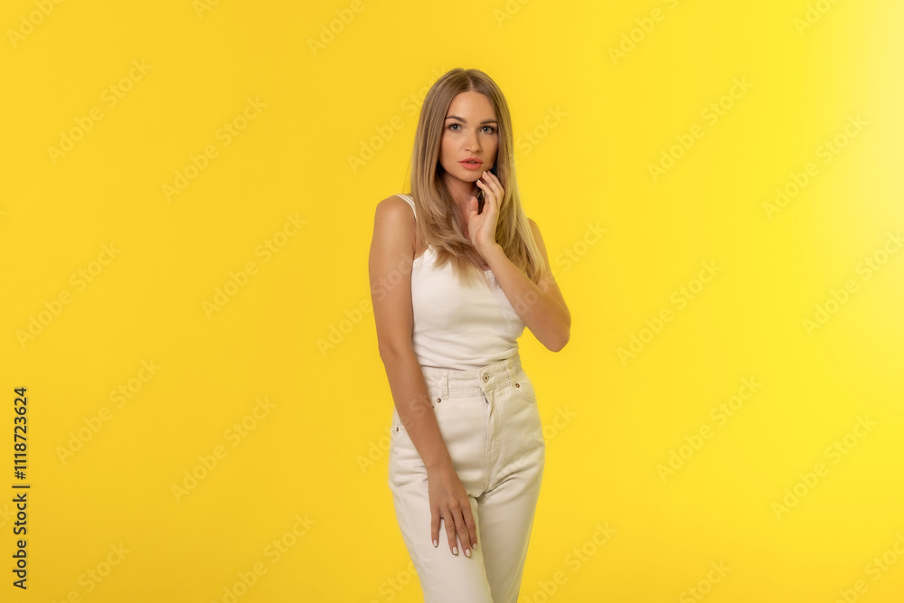 A young woman poses gracefully against a vibrant yellow backdrop, showcasing a stylish white outfit with a confident expression A young woman poses gracefully against a vibrant yellow backdrop, showcasing a stylish white outfit with a confident expression