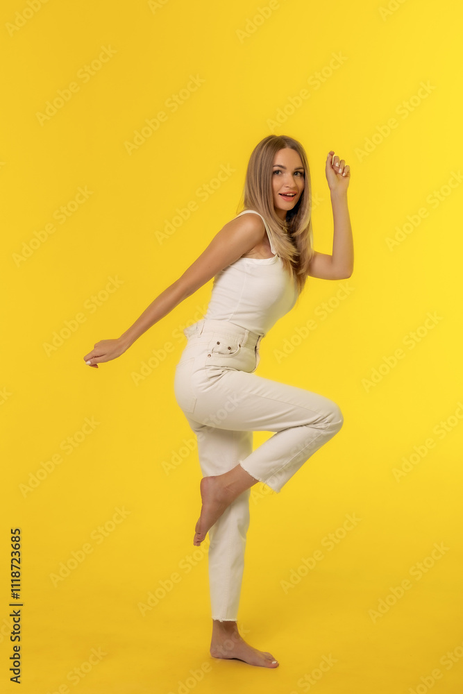 A joyful woman strikes a playful pose against a vibrant yellow background in a bright studio setting A joyful woman strikes a playful pose against a vibrant yellow background in a bright studio setting