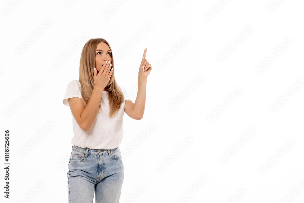 A surprised woman gestures upward with one finger while looking astonished against a white background in a casual setting A surprised woman gestures upward with one finger while looking astonished against a white background in a casual setting