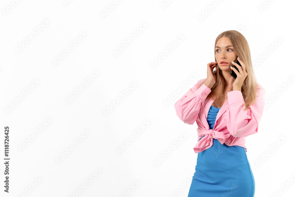 Young woman in a pink jacket and blue dress talking on her smartphone in a bright, neutral setting Young woman in a pink jacket and blue dress talking on her smartphone in a bright, neutral setting
