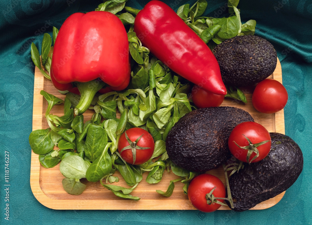 Ripe Avocado on a Wooden Board with Fresh Spinach, Red Tomatoes, and Red Peppers Ripe Avocado on a Wooden Board with Fresh Spinach, Red Tomatoes, and Red Peppers