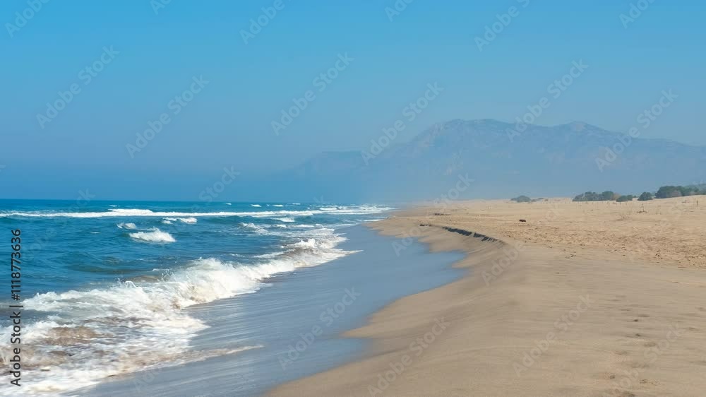 Turquoise waves crash against a deserted sandy beach, framed by majestic mountains in the background. A serene landscape evokes feelings of tranquility and relaxation in a tropical paradise Turquoise waves crash against a deserted sandy beach, framed by majestic mountains in the background. A serene landscape evokes feelings of tranquility and relaxation in a tropical paradise