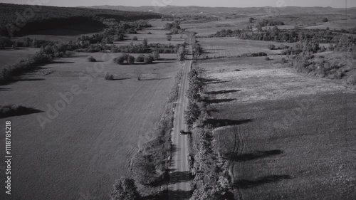 Archive Vintage Ford Model A from 1928 Driving on an empty road, black and white