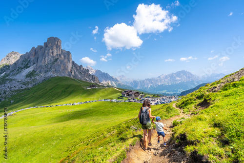 Tourists hiking in the dolomites, giau pass in summer, italy