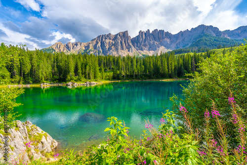 Fototapeta Naklejka Na Ścianę i Meble -  Latemar mountain group reflecting in the emerald water of lake carezza in summer