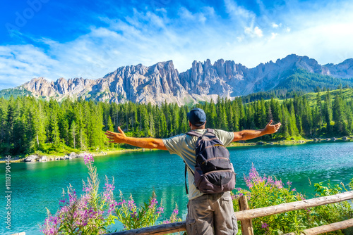 Tourist enjoying the breathtaking view of lake carezza and the dolomites in summer