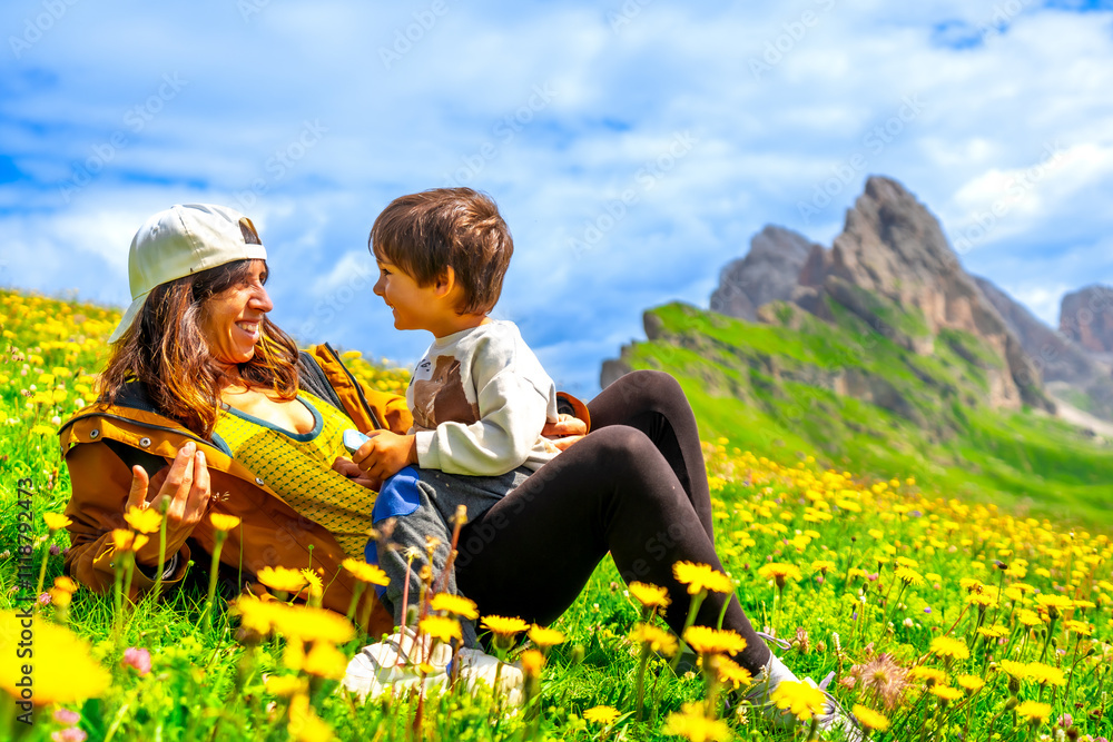 Fototapeta premium Mother and son enjoying the view of seceda mountains in the dolomites