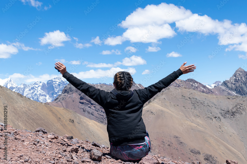 Mujer empoderada disfrutando su libertad en la cima de la montaña