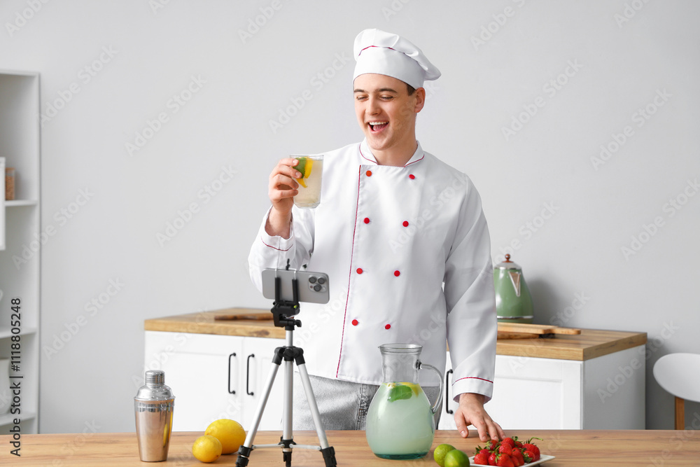 Male chef recording video of him making homemade lemonade in kitchen Male chef recording video of him making homemade lemonade in kitchen