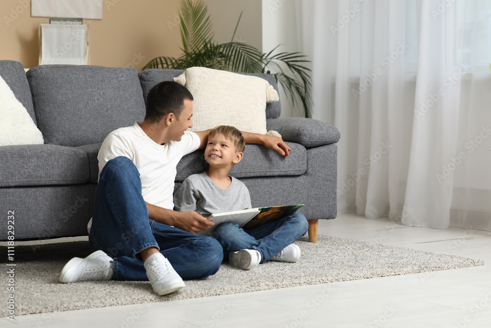 Happy father with his little son reading book on floor at home Happy father with his little son reading book on floor at home