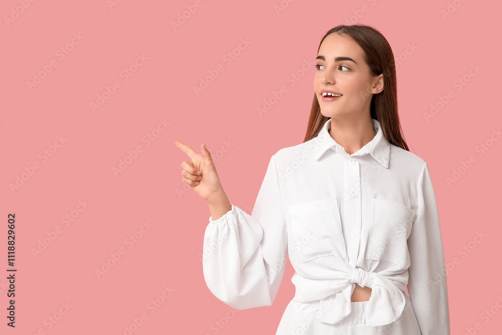 Young woman with diastema pointing at something on pink background Young woman with diastema pointing at something on pink background