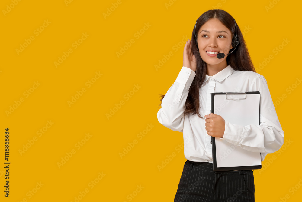 Female Asian technical support agent in headset with clipboard on yellow background Female Asian technical support agent in headset with clipboard on yellow background