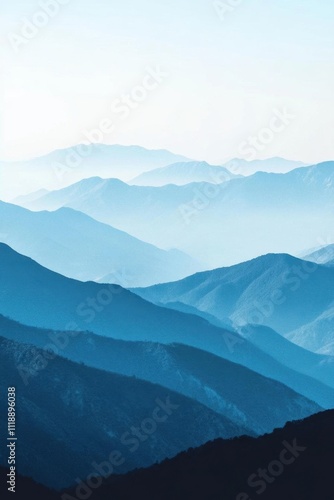 Serene mountain landscape with layered blue hues and misty atmosphere.