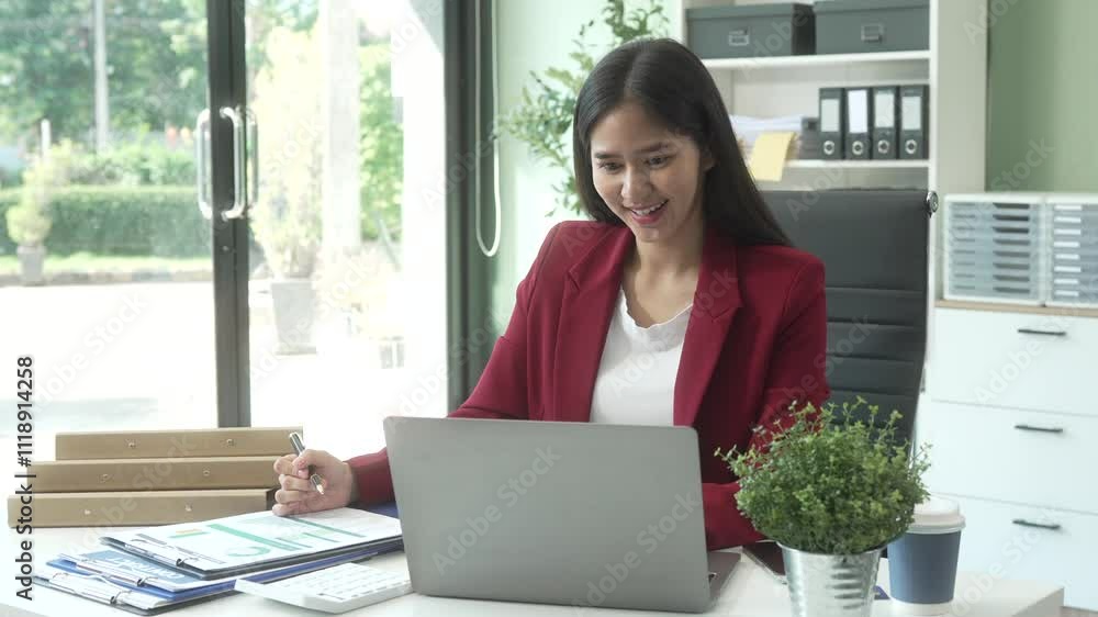 A young Asian woman works diligently at her desk in a bright office room during the day. Surrounded by files, charts, and devices, she strategies on marketing funnels and SEO optimization. A young Asian woman works diligently at her desk in a bright office room during the day. Surrounded by files, charts, and devices, she strategies on marketing funnels and SEO optimization.