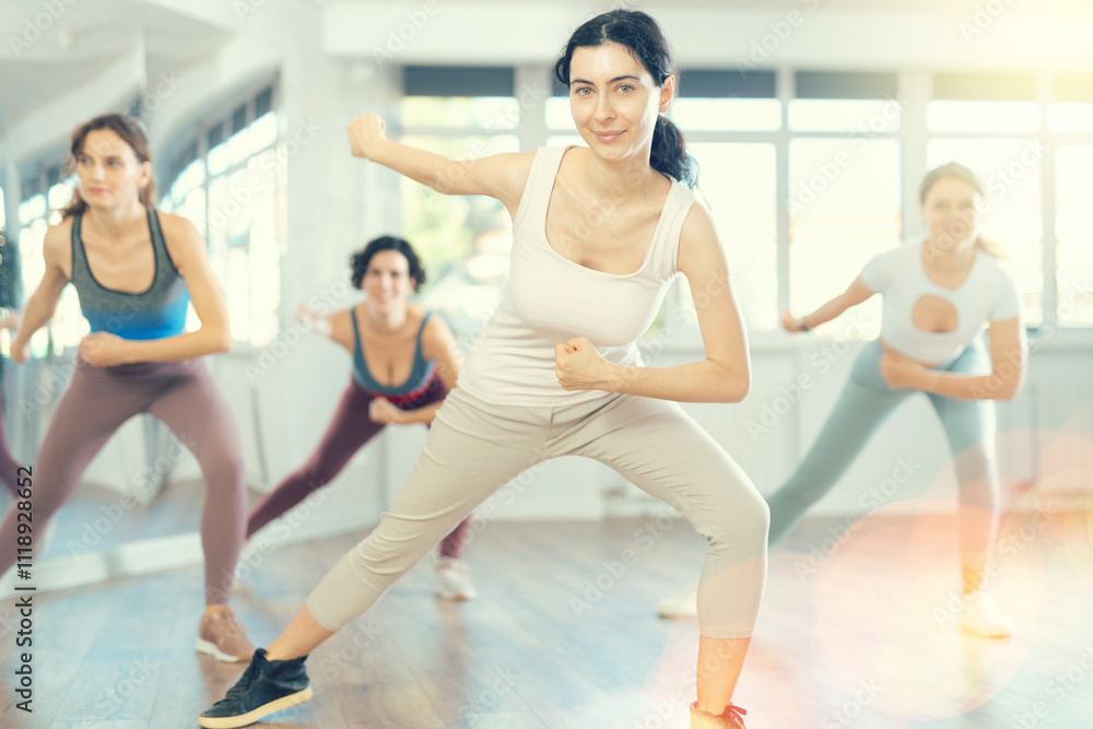 Enthusiastic young girl honing hip-hop moves in dance studio setting with group of women.. Enthusiastic young girl honing hip-hop moves in dance studio setting with group of women..