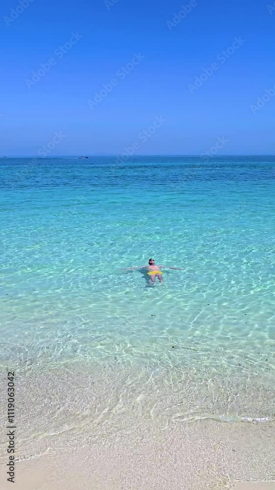 Bask in the serene beauty of Koh Munnork Island, where crystal-clear waters invite relaxation. Men swim in the vibrant sea and embrace the tropical escape under the sun. Bask in the serene beauty of Koh Munnork Island, where crystal-clear waters invite relaxation. Men swim in the vibrant sea and embrace the tropical escape under the sun.
