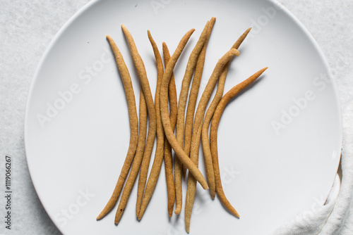 Top view of fried corn stick snack on a white plate, Overhead view of nigerian kokoro corn snack photo