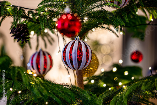 Close-up of Christmas tree with red balls and bokeh in the background.