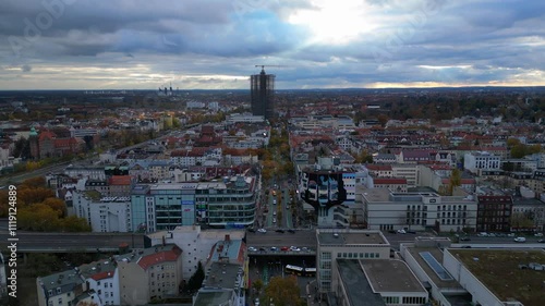 Cityscape of berlin featuring schlossstrasse in Steglitz, a construction crane, buildings, trees, and a cloudy sky. Great aerial view flight descending drone photo