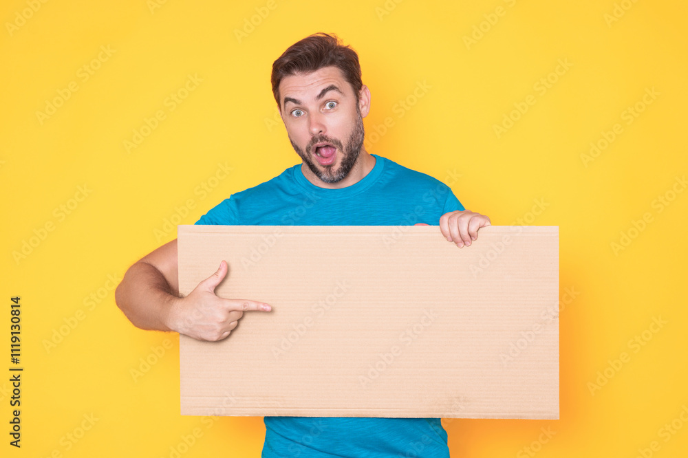 Man holds sign, blank card. Placard ready for your product. Man showing blank sign board over studio isolated background, pointing finger. Empty blank board. Area for advertising, copy space. Man holds sign, blank card. Placard ready for your product. Man showing blank sign board over studio isolated background, pointing finger. Empty blank board. Area for advertising, copy space.