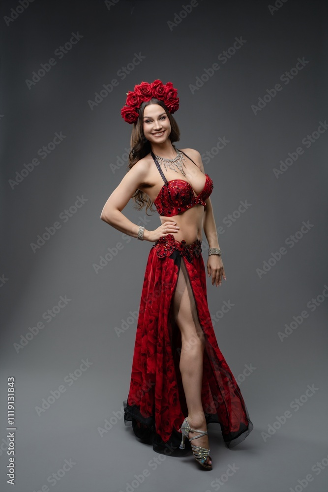 Elegant dancer in red attire with floral headpiece poses for a studio portrait Elegant dancer in red attire with floral headpiece poses for a studio portrait
