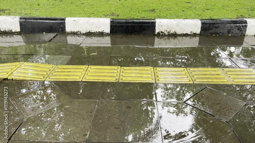 sidewalks with yellow lines accompanied by rain 
