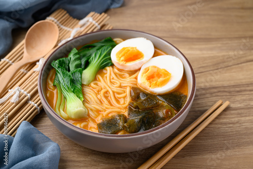 Spicy noodles soup with egg, seaweed and bok choy in bowl, Asian noodles style