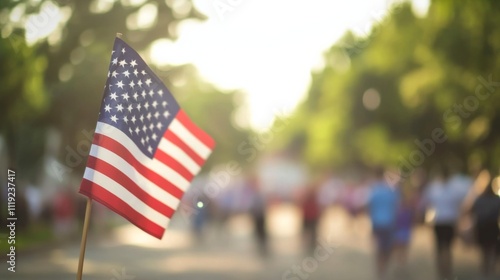 American flag waving on urban street with blurred crowd background, low angle capture evoking patriotic celebration.