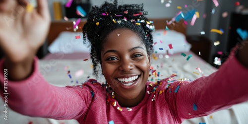 Joyful woman with afro hair joyfully throws colorful confetti, capturing the essence of celebration and happiness in a candid, uplifting moment. photo