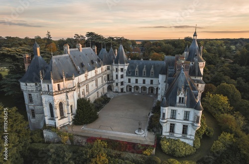 Majestic castle surrounded by lush greenery at sunset revealing architectural elegance and historical charm photo