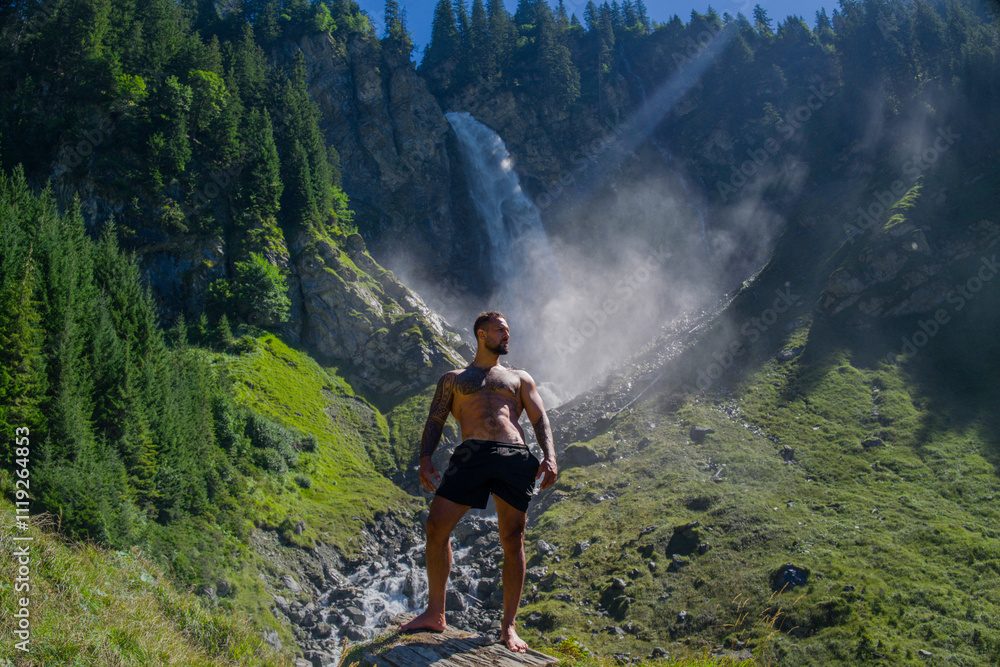 Obraz premium Man tourist on summer vacation. Full length photo of Hispanic man with naked sexy torso on summer vacation. Hiker guy outside. Tourist man walking on the waterfall landscape. Man Traveling and nature.