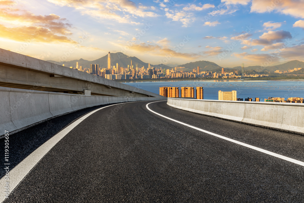 Asphalt highway road and city skyline with modern buildings scenery at sunset in Shenzhen. Outdoor city road.
