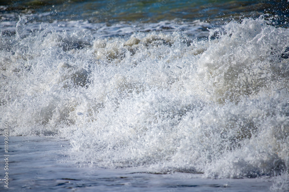 A sea wave breaks against the rocks, water splashes in the sky. Tidal wave. A sea wave breaks against the rocks, water splashes in the sky. Tidal wave.