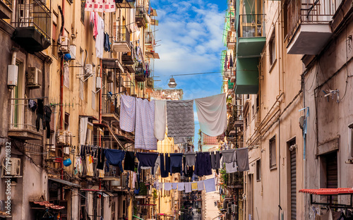 Fototapeta Naklejka Na Ścianę i Meble -  city view of old down town street of slum area with vintage facades of buildings and drying clothes above old urban street