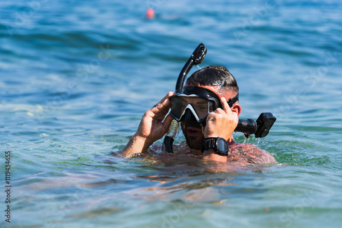 A male snorkels with an action camera at Mediterranean sea in the summer, close-up photo. photo