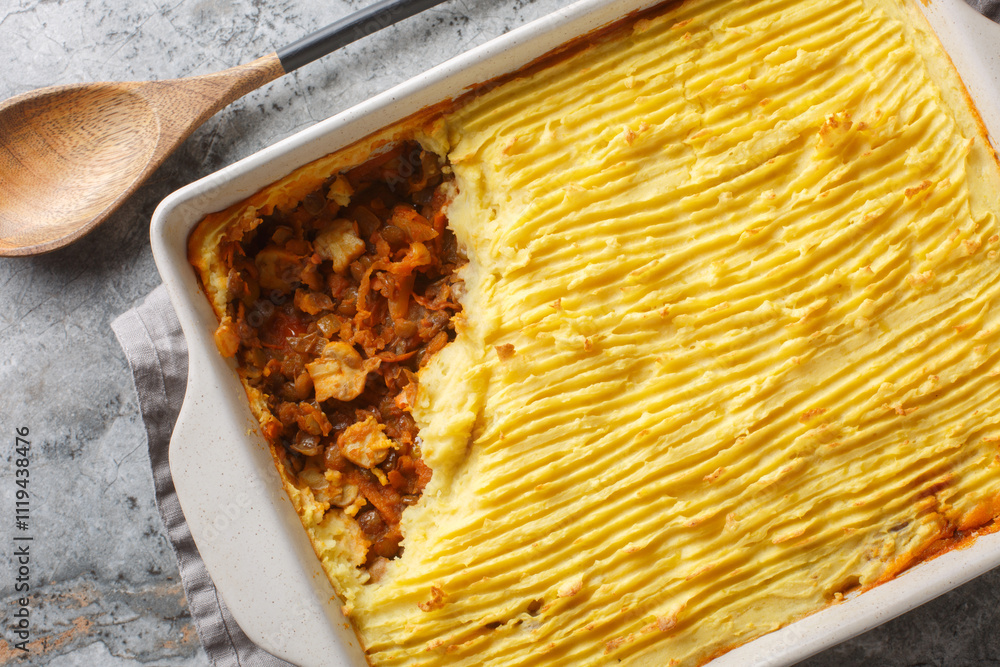 Mushroom meatless shepherd's pie without meat with lentils, onions, tomatoes, carrots close-up in a baking dish on the table. Horizontal top view from above