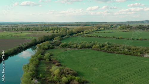 Breathtaking landscape from a height: the river meandering through the fields offers a unique view from a drone. Natural beauty and harmony of water and green spaces.