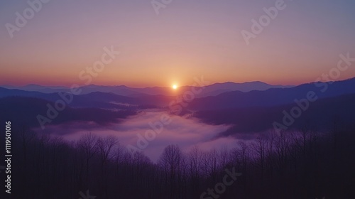 Sunrise over misty mountain range.