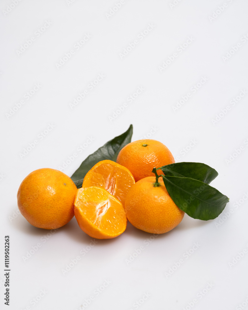 oranges and tangerines with leaves whole and in size lie on a white background oranges and tangerines with leaves whole and in size lie on a white background