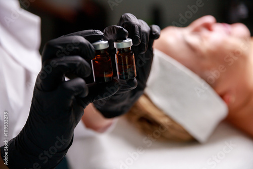 A cosmetologist holds two ampoules for a skincare procedure, symbolizing precision and professional care in beauty treatments.