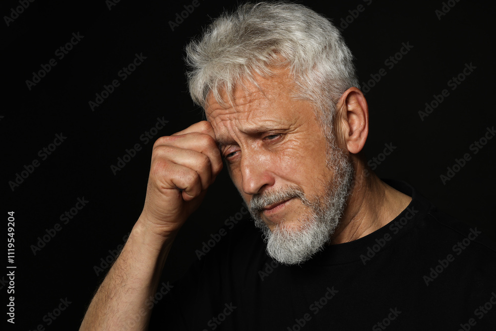 Sad senior man crying on black background Sad senior man crying on black background