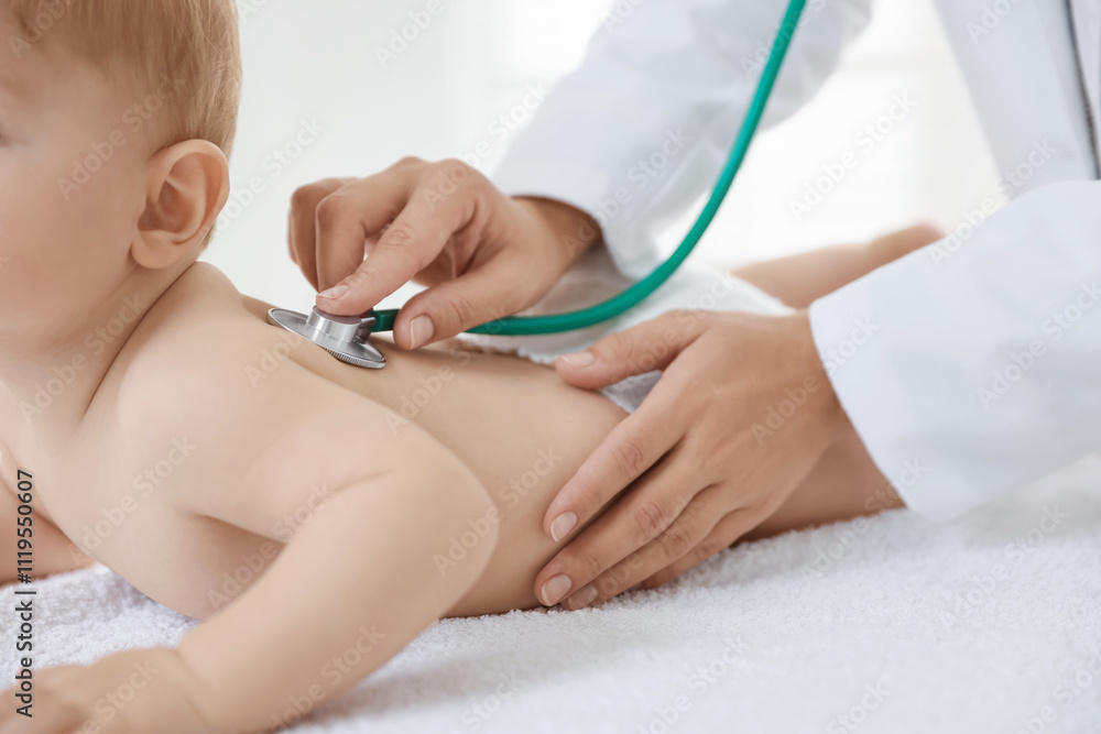 Pediatrician examining little child with stethoscope in clinic, closeup. Checking baby's health Pediatrician examining little child with stethoscope in clinic, closeup. Checking baby's health