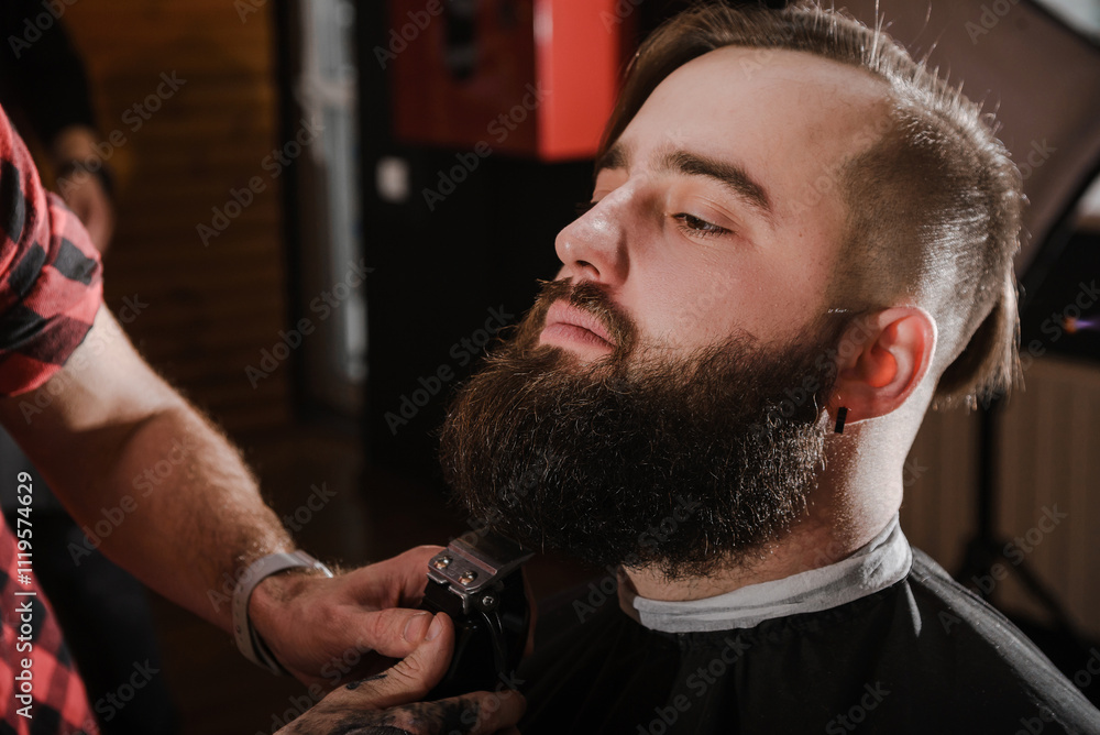 Fototapeta premium Portrait of hipster in barbershop. Close up serious bearded man.Barbershop concept. Modern stylish haircut.