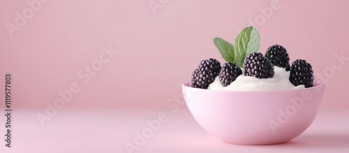 Fresh blackberries and cream in bowl with mint vertical .