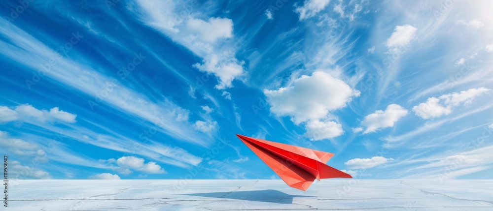 A vibrant red paper airplane soars against an expansive blue sky with soft, wispy clouds, symbolizing freedom and imagination. A vibrant red paper airplane soars against an expansive blue sky with soft, wispy clouds, symbolizing freedom and imagination.
