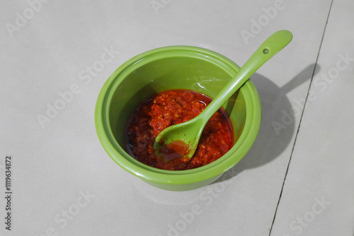 Stir-fried red chili sauce in a small bowl on the dining table